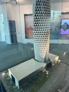 Architectural scale model made of Hamad port control tower with intricate hexagonal parametric facade design in exhibition hall.